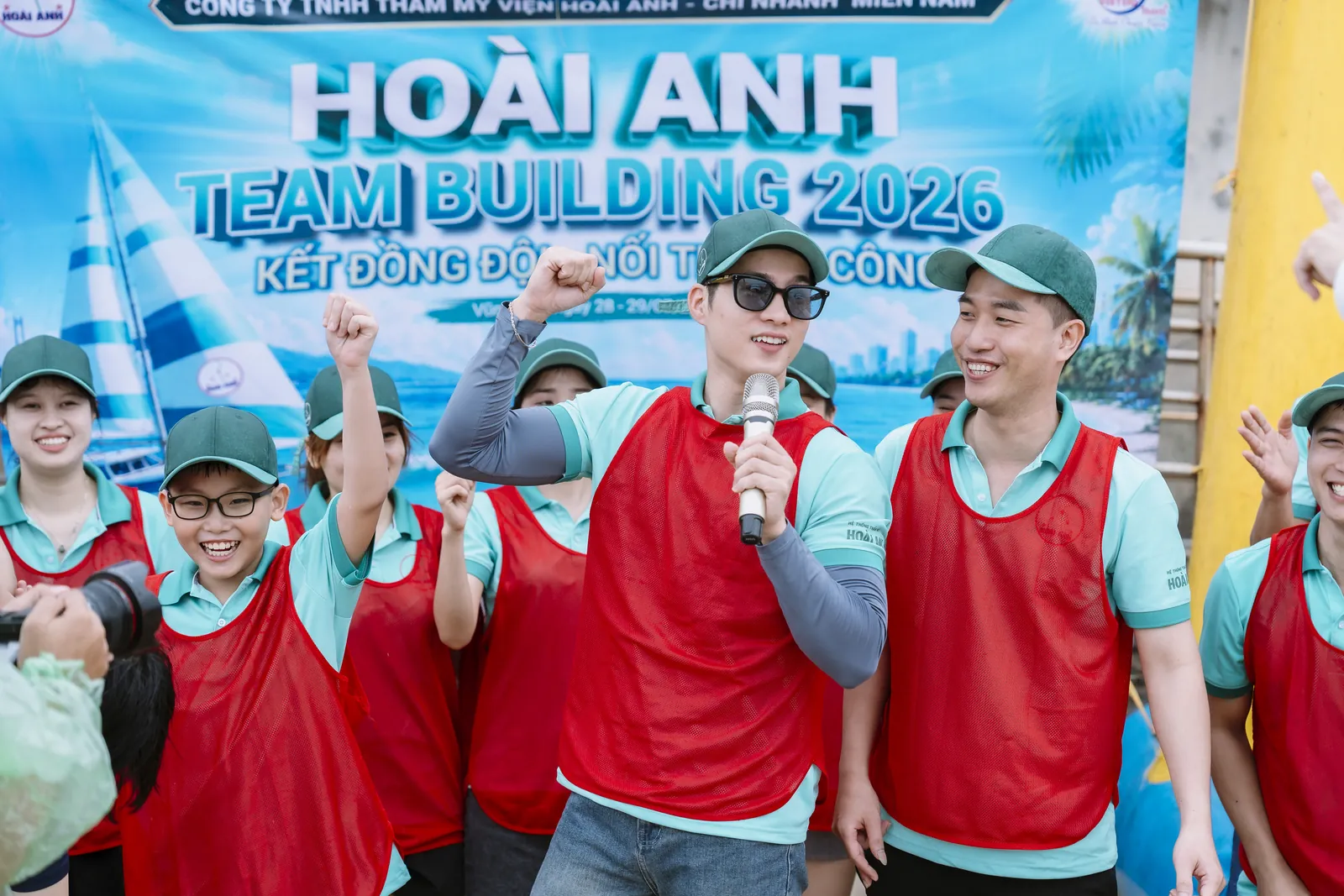 Đội Đỏ trước băng rôn “Kết đồng đội – Nối thành công” — Team building trên bãi biển, Thẩm mỹ viện Hoài Anh